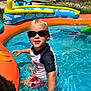 Colby is registered to the contest to win money with this photo: child, pool, water, sunglasses, summer, outdoor, inflatable, toy, swimming, splashing, sunlight, backyard, happy, boy, shorts, rash_guard, play, fun, blue, yellow