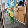 Colby joined the competition — help win amazing prizes! child, costume, dinosaur, green, kitchen, cabinet, floor, barefoot, curious, indoor, person, appliance, countertop, wood, home, furniture, toy, cup, decor, light