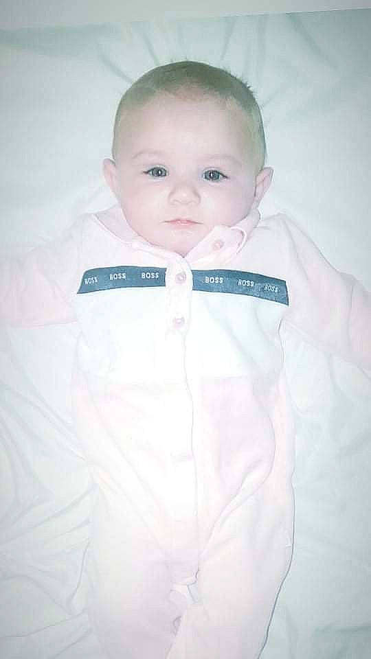 Alix participe au concours pour gagner de l'argent avec cette photo : baby, baby_toddler_clothing, bedding, chest, child, comfort, electric_blue, eye, eyebrow, face, flash_photography, happy, head, iris, linens, person, pink, sleeve, smile, t_shirt