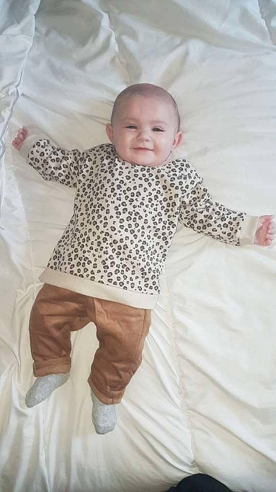 Alix participe au concours pour gagner de l'argent avec cette photo : baby, baby_products, baby_toddler_clothing, bedding, child, comfort, face, fun, happy, joy, linens, outerwear, pattern, person, pink, room, sleeve, smile, t_shirt, textile