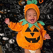 Maxyne joined the competition — help win amazing prizes! baby, pumpkin_costume, halloween, blanket, smiling, infant, cute, holiday, festive, costume, child, orange, green, fabric, pattern, lying_down, happy, face, diaper, celebration