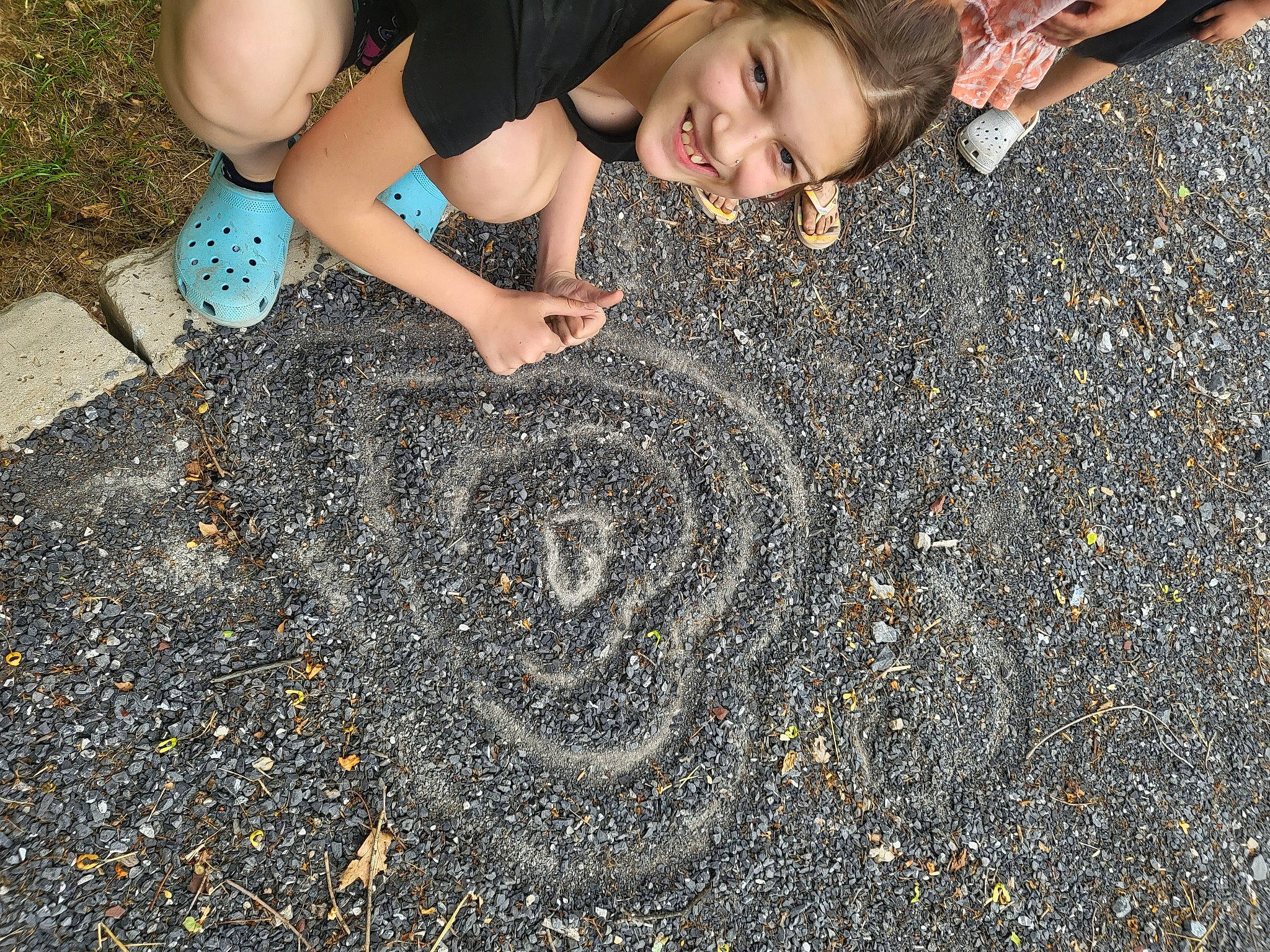 Sara joined the competition — help win amazing prizes! asphalt, automotive_tire, child, circle, environmental_art, flooring, foot, fun, grass, happy, human_leg, joy, pattern, people_in_nature, person, road_surface, sand, sidewalk, smile, soil