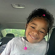 Autumn joined the competition — help win amazing prizes! child, smile, curly_hair, beads, tshirt, car_interior, seat, window, natural_light, portrait, happy, person, face, hair_accessory, casual_clothing, young, cute, indoors, seatbelt, head