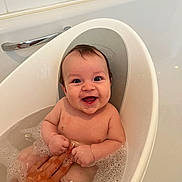 Luca is registered to the contest to win money with this photo: baby, bathtub, bath, bubbles, child, smile, happy, water, skin, hand, fingers, person, indoor, bathroom, tiled_wall, toy, cute, infant, clean, relaxed