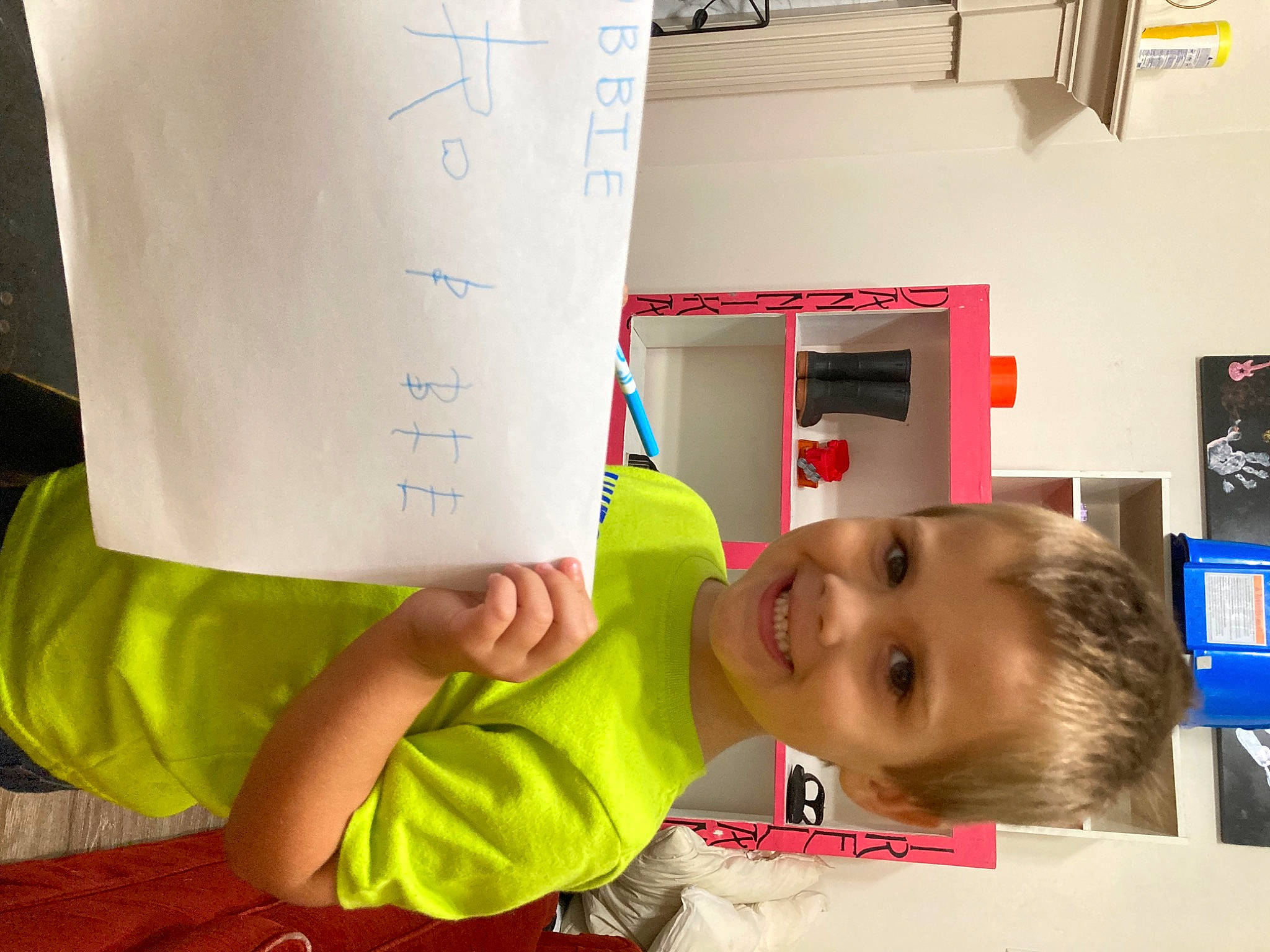 Robert is registered to the contest to win money with this photo: child, flooring, font, fun, handwriting, happy, house, joy, knee, leisure, person, picture_frame, play, room, smile, t_shirt, thumb, toddler, writing, yellow