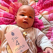 Sam a rejoint le concours — aidez-le/la à gagner de superbes lots ! baby, infant, child, milestone_card, blanket, floral_pattern, pink, face, expression, lying_down, cute, clothing, hand, skin, head, indoors, portrait, young, person, soft