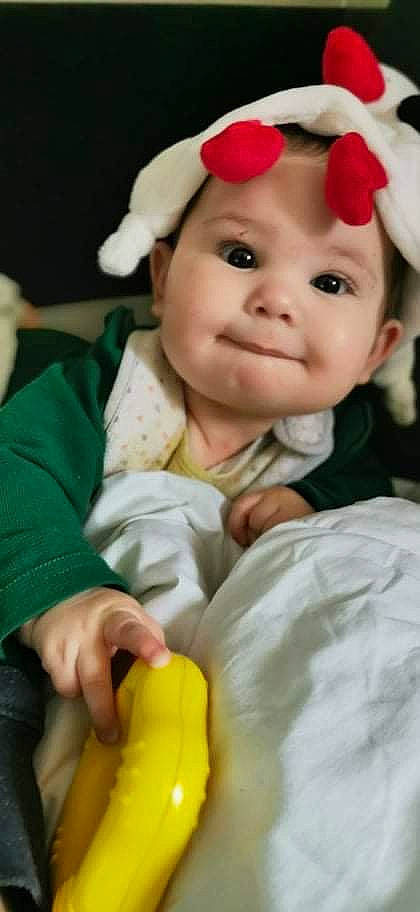 Emmy participe au concours pour gagner de l'argent avec cette photo : baby, baby_toddler_clothing, cap, cheek, child, costume_hat, dress, eye, fun, gesture, happy, hat, head, headband, headwear, nose, person, petal, skin, sleeve