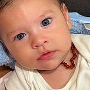 Jude participe au concours pour gagner de l'argent avec cette photo : baby, infant, face, eyes, necklace, clothing, onesie, blanket, hand, skin, cute, portrait, child, young, human, expression, indoors, closeup, soft, warm