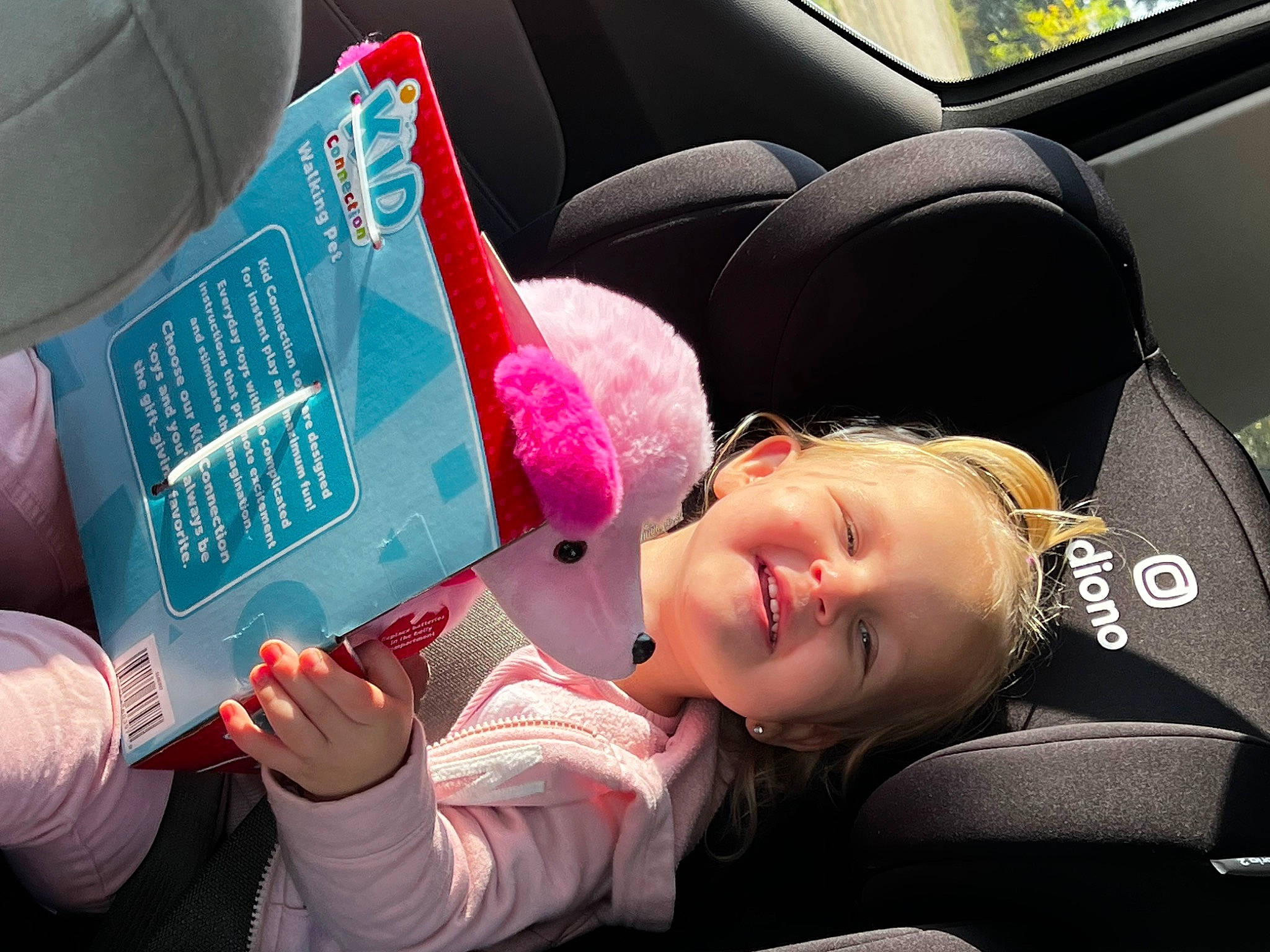 Paige is registered to the contest to win money with this photo: automotive_design, baby, baby_products, book, car_seat, car_seat_cover, child, comfort, cool, facial_expression, fun, hairstyle, happy, headgear, human, motor_vehicle, person, product, smile, toddler