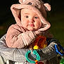 baby, bonnet, cap, clothing, coat, face, hat, head, hood, jacket, person, photography, pingpong, pingpongpaddle, portrait, racket, sitting, sport, sunhat, toy