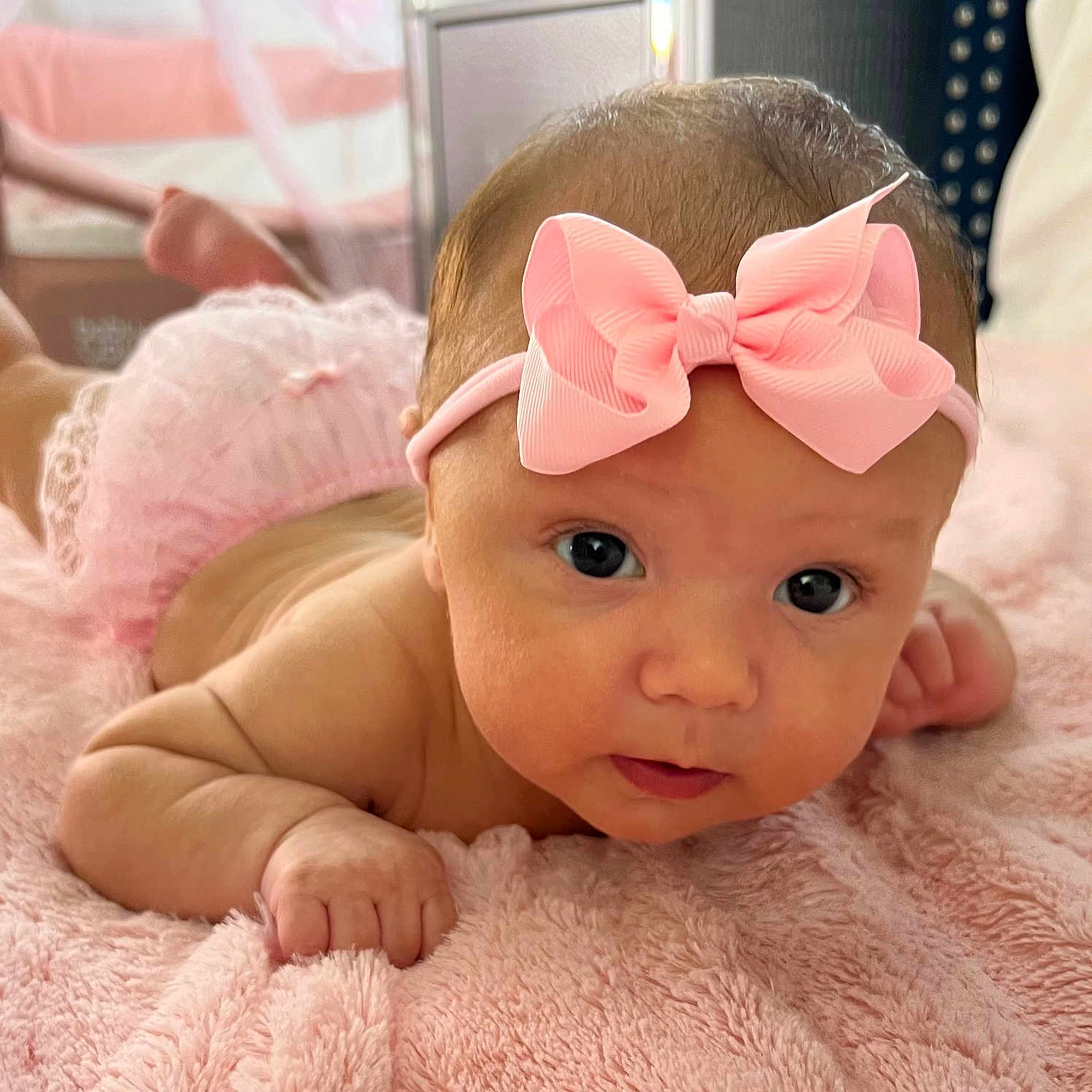 Saishel is registered to the contest to win money with this photo: baby, baby_girl, blanket, child, curious, cute, diaper_cover, eyes, face, hand, headband, indoor, infant, pink_bow, portrait, resting, skin, soft_texture, tummy, young_child
