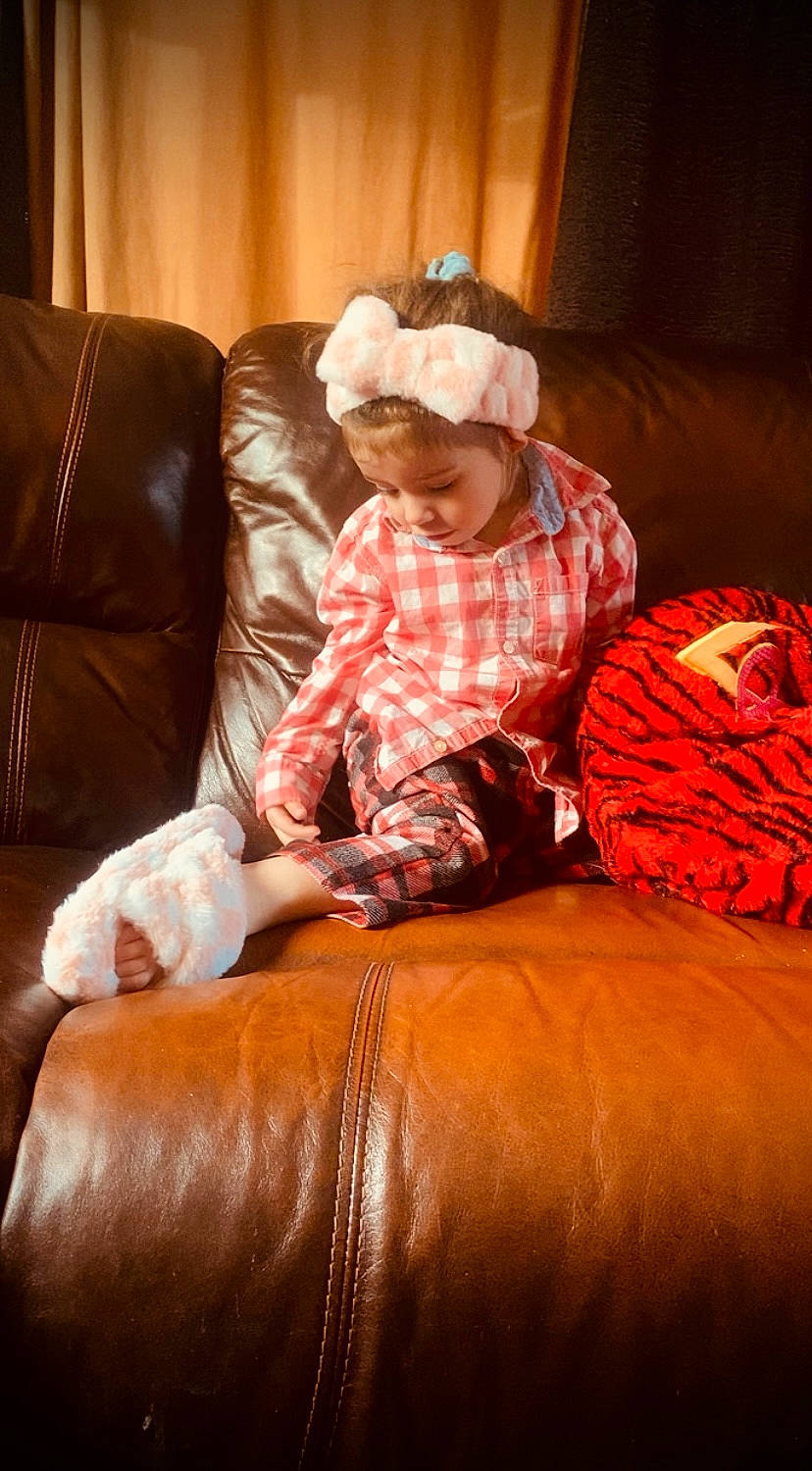 Madison participe au concours pour gagner de l'argent avec cette photo : comfort, couch, flooring, fun, fur, gourd, hardwood, human_leg, lap, living_room, pattern, peach, person, pumpkin, room, sitting, sofa_bed, studio_couch, textile, toddler