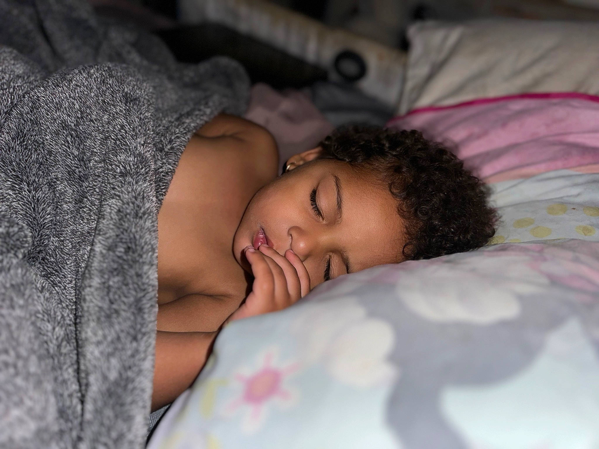 Jaylani is registered to the contest to win money with this photo: arm, bed, bedding, bedtime, black_hair, comfort, eye, eyebrow, eyelash, face, fur, hand, happy, head, human_body, linens, nap, pattern, person, textile