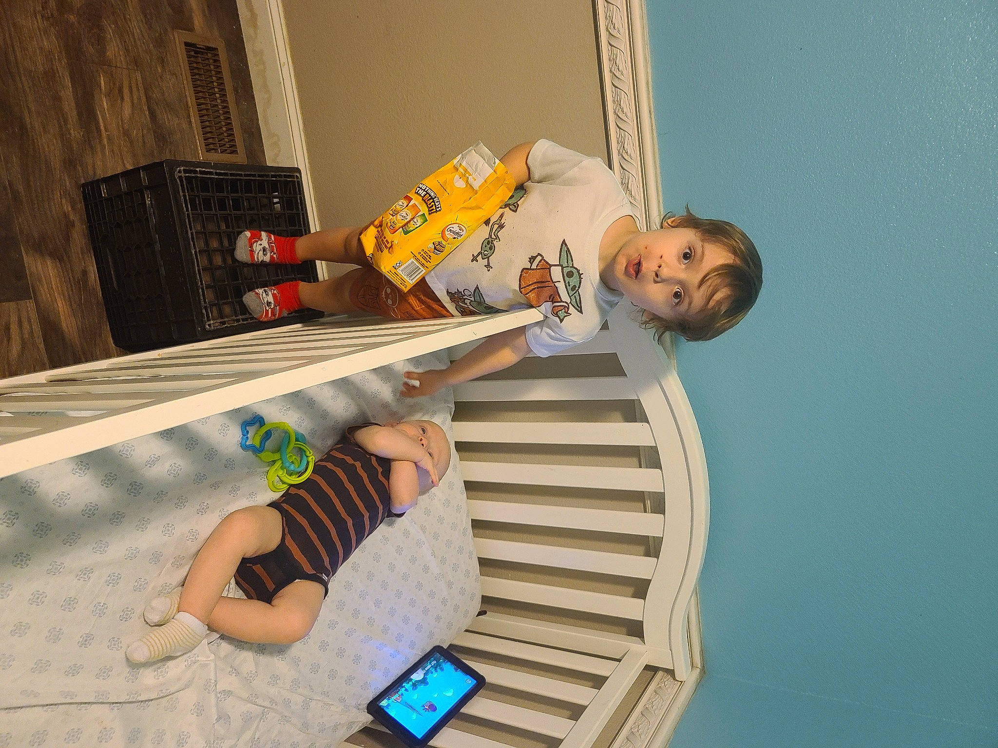 Malachi is registered to the contest to win money with this photo: building, child, communication_device, elbow, fun, house, leisure, mobile_phone, outdoor_furniture, person, portable_communications_device, room, sky, surprise, t_shirt, table, thigh, toddler, vacation, wood