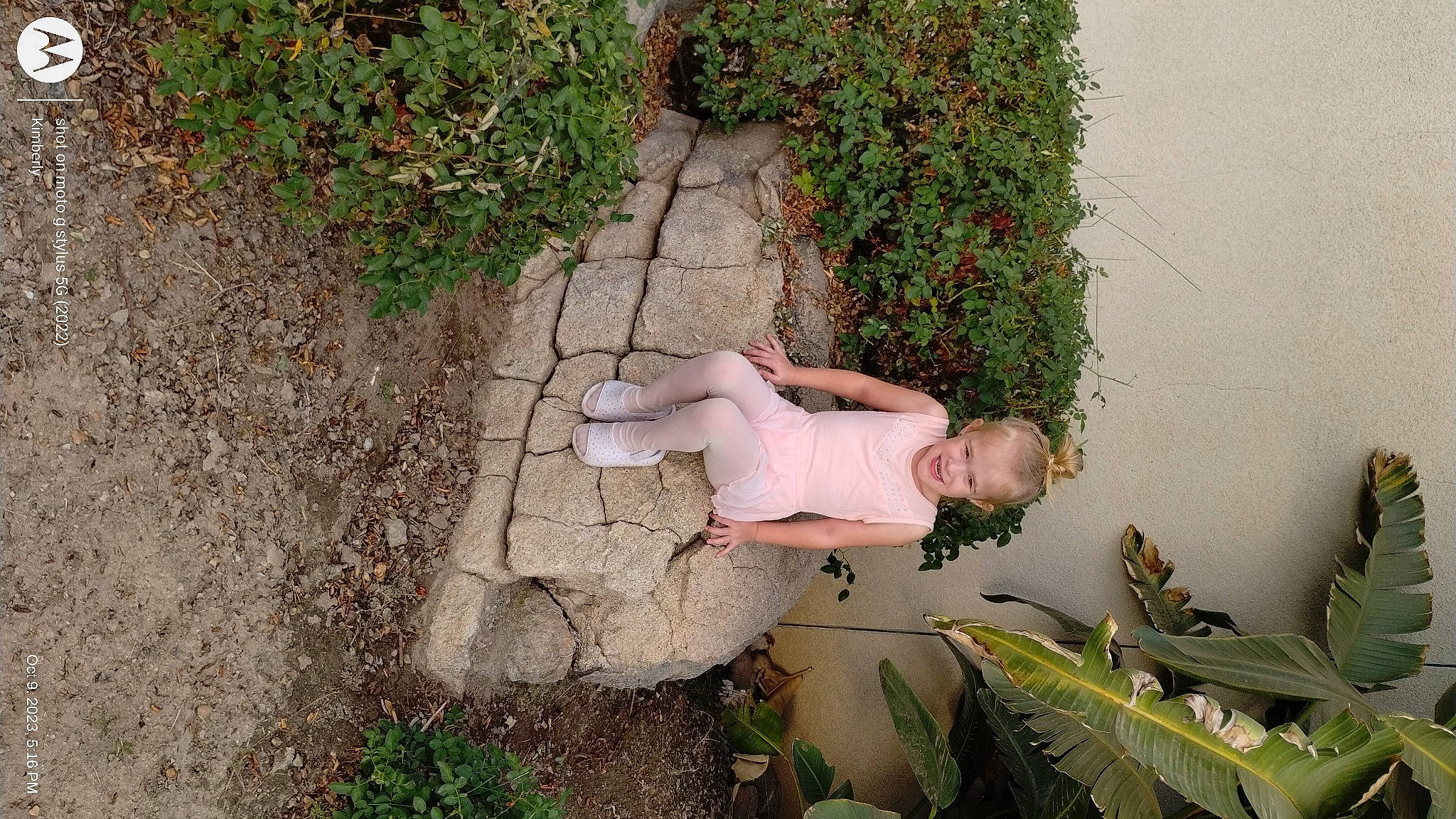 Rayne is registered to the contest to win money with this photo: concrete, foot, garden, grass, groundcover, human_leg, joy, landscape, leisure, people_in_nature, person, plant, road_surface, sandal, shadow, shrub, sidewalk, sitting, soil, terrestrial_plant