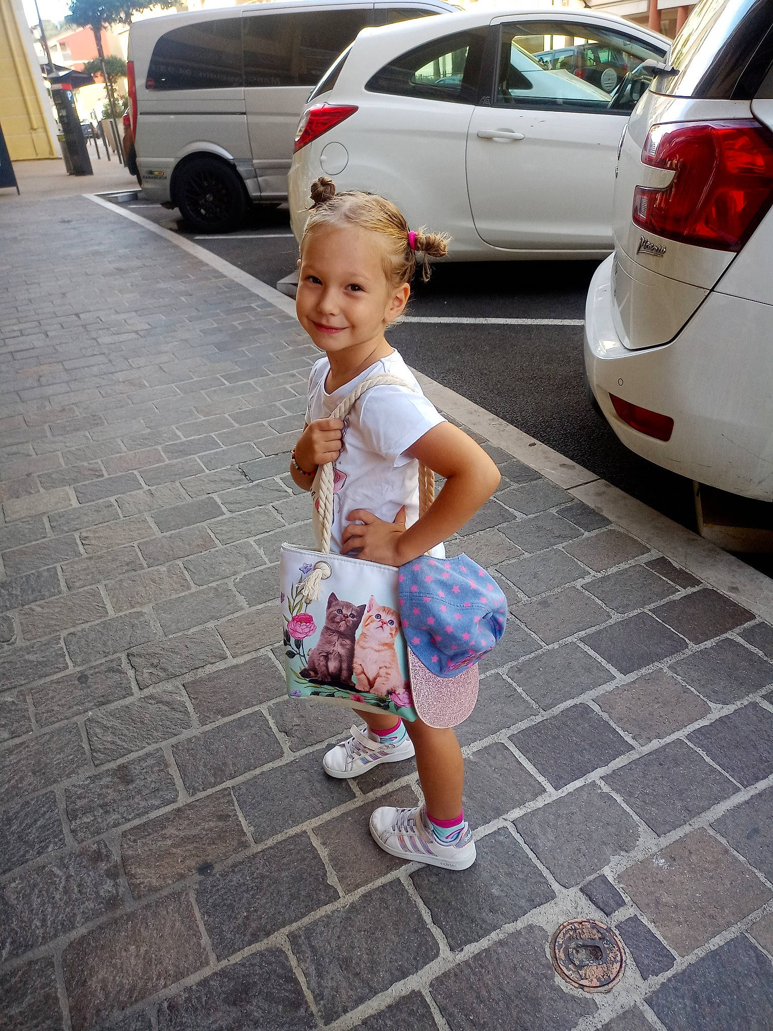 Manon a rejoint le concours — aidez-le/la à gagner de superbes lots ! asphalt, automotive_design, automotive_exterior, automotive_lighting, car, joy, motor_vehicle, parking, person, personal_luxury_car, photograph, public_space, road, road_surface, shorts, sidewalk, smile, snapshot, tire, toddler