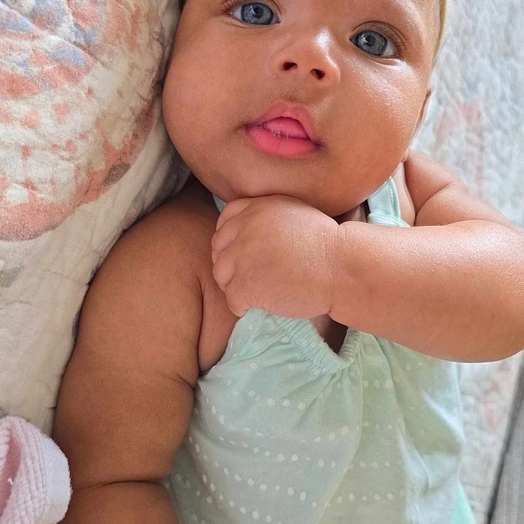 Kalyni is registered to the contest to win money with this photo: adorable, baby, baby_clothes, blue_eyes, child, close_up, cute, expression, face, hand, headband, indoor, infant, lying_down, mint_green, polka_dot, portrait, quilt, skin, soft_light