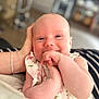 Isabel is registered to the contest to win money with this photo: baby, child, closeup, cute, face, floral_dress, hand, happy, head, holding, human, indoor, infant, newborn, person, portrait, skin, smile, soft_focus, toddler