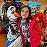 amusement_ride, background, child, clothing, colorful, entertainment, floor, fun, girl, happy, indoor, lights, people, plaid_shirt, play_area, portrait, red_jacket, smile, snowman, toy
