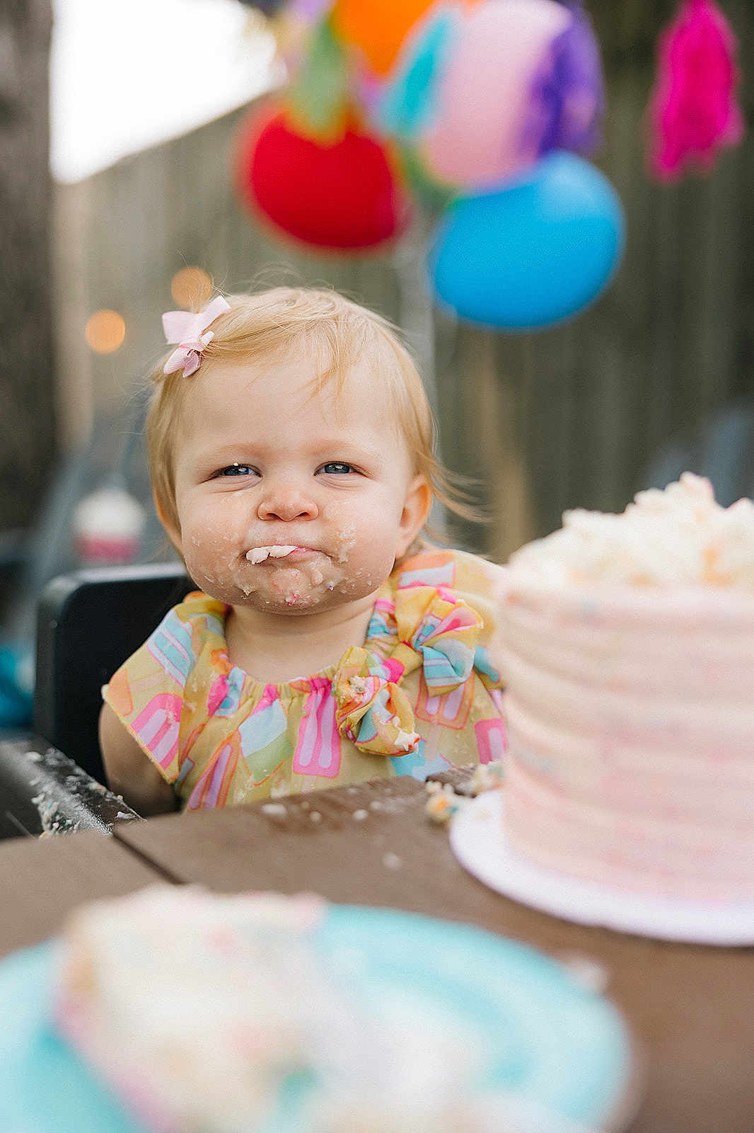 Ellyette is registered to the contest to win money with this photo: toddler, child, cake, birthday, high_chair, balloons, pink_bow, messy_face, frosting, party, celebration, outdoor, table, plate, colorful, happy, portrait, food, fun, smile