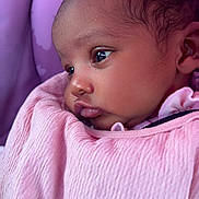 Arya is registered to the contest to win money with this photo: baby, child, close_up, clothing, curious, cute, expression, face, head, indoors, infant, newborn, person, pink_blanket, portrait, seat, skin, sleeping_bag, soft_lighting, young