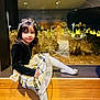 child, clothing, face, female, footwear, girl, hardwood, head, indoors, interiordesign, lighting, pants, person, photography, plant, portrait, pottedplant, shoe, sitting, wood