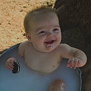 Westyn joined the competition — help win amazing prizes! baby, child, smiling, cookie, milk_bath, outdoor, metal_tub, water, dirt, happy, face, hand, skin, playful, sunlight, tree, nature, messy, cute, infant