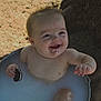 baby, child, smiling, cookie, milk_bath, outdoor, metal_tub, water, dirt, happy, face, hand, skin, playful, sunlight, tree, nature, messy, cute, infant