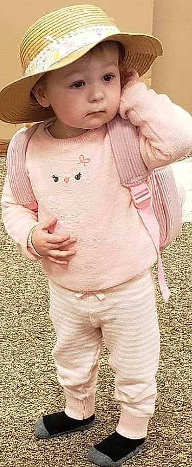 Briella is registered to the contest to win money with this photo: baby, baby_toddler_clothing, cheek, chest, child, gesture, grass, hand, happy, hat, headwear, lip, nose, outerwear, pattern, person, pink, skin, sleeve, t_shirt