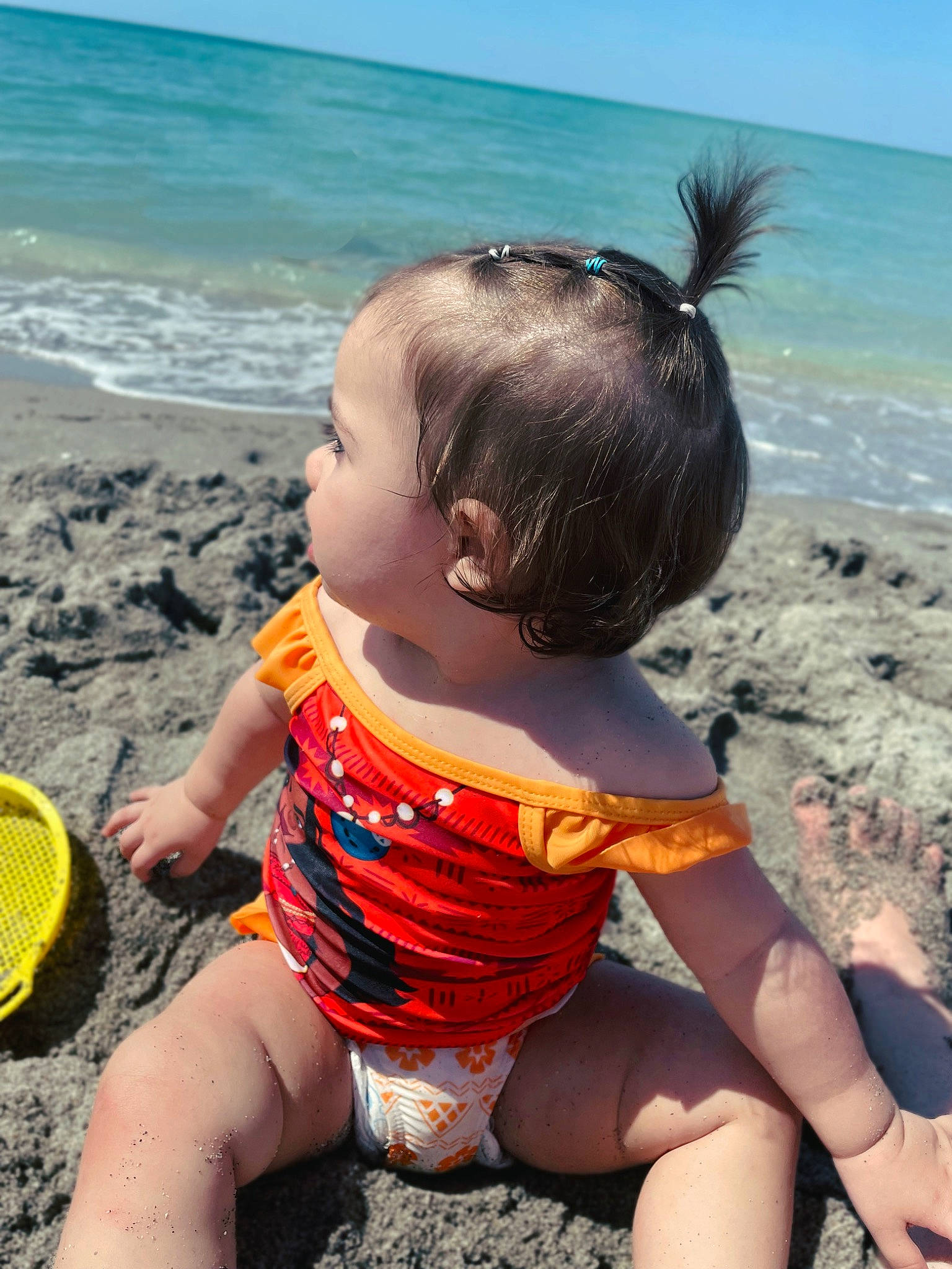 Raelynn is registered to the contest to win money with this photo: arm, beach, blue, clothing, fun, hairstyle, happy, leg, leisure, light, people_in_nature, people_on_beach, person, photograph, shorts, skin, sky, summer, thigh, toddler