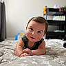 baby, infant, child, blanket, star_pattern, curious, smiling, face, indoors, furniture, toy, bedroom, soft_light, crawling, cute, portrait, hands, head, expression, young