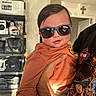 Evan joined the competition — help win amazing prizes! baby, sunglasses, child, person, hand, shirt, harley_davidson, garage, shelf, helmet, cool, smile, indoor, light, shadow, casual, clothing, face, adult_hand, reflection