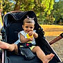 Seyana participe au concours pour gagner de l'argent avec cette photo : baby, child, stroller, toy, yellow, smile, happy, outdoor, park, greenery, hair_ties, cute, infant, safety_belt, legs, feet, summer, daylight, playful, portrait