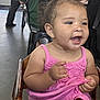 Jersey joined the competition — help win amazing prizes! toddler, child, smiling, pink_dress, high_chair, indoor, happy, person, seated, curly_hair, light_skin, wooden_furniture, casual_clothing, cute, baby, young_child, holding_cloth, expression, face, people