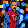 child, smiling, curly_hair, red_shirt, blue_jacket, standing, portrait, bokeh_background, colorful_lights, happy, casual_clothing, young, person, indoor, photography, cute, expressive_face, fashion, playful, vibrant