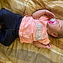baby, sleeping, pacifier, pink_shirt, dark_pants, blanket, infant, resting, cute, child, peaceful, indoors, soft_lighting, portrait, one_person, young_child, casual_clothing, head, hand, footwear