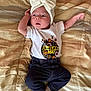 baby, infant, bow_headband, tshirt, fleetwood_mac, pants, socks, blanket, lying_down, cute, child, young, portrait, indoors, soft_lighting, clothing, apparel, expression, relaxed, small