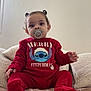 Mahira a rejoint le concours — aidez-le/la à gagner de superbes lots ! baby, bed, blanket, child, cozy, cute, hair_buns, holiday_theme, indoor, onesie, pacifier, person, pillow, portrait, red_clothing, sitting, smile, stitch_character, toddler, young_child