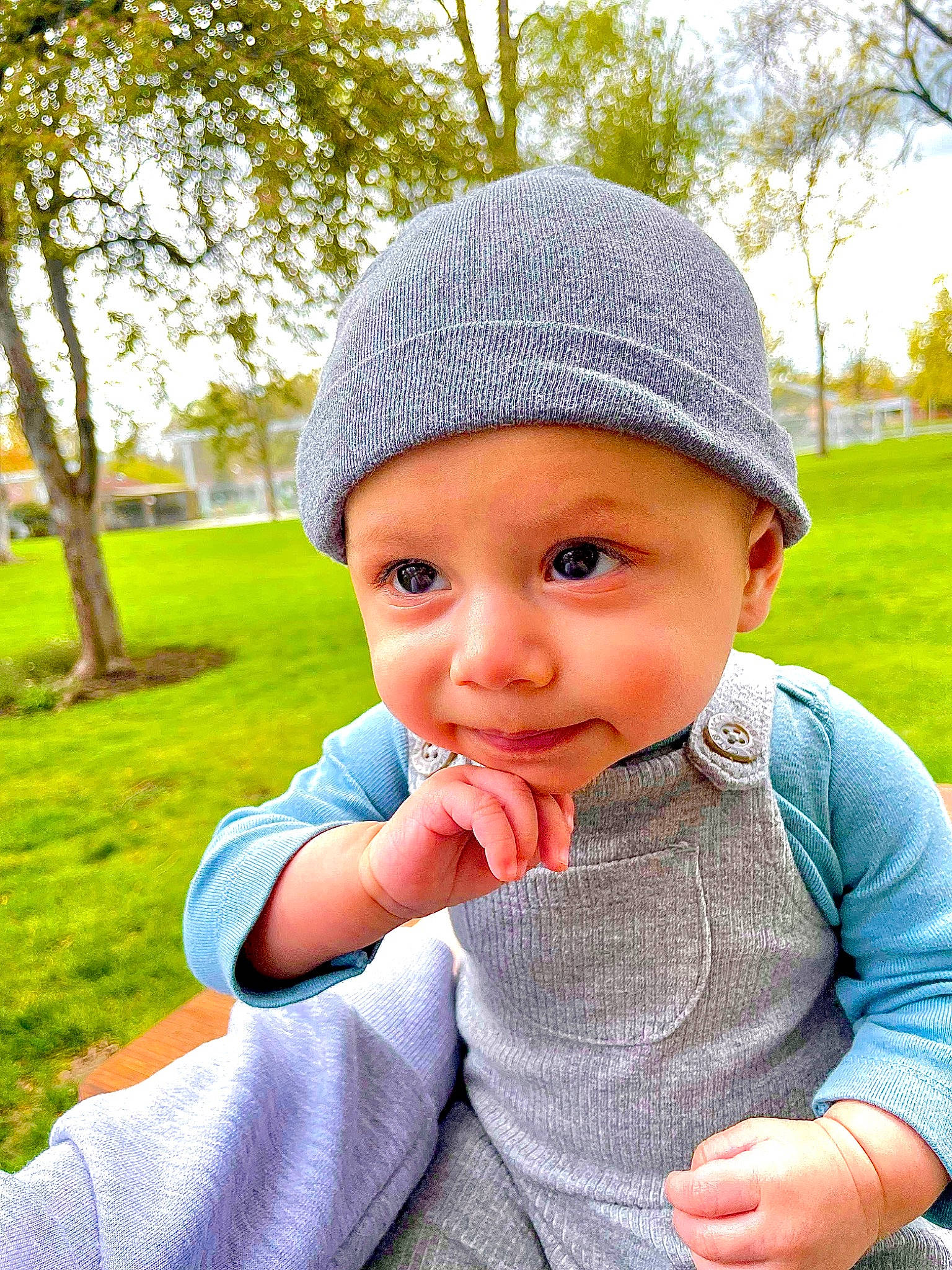 Callum is registered to the contest to win money with this photo: baby, baby_toddler_clothing, cap, child, clothing, electric_blue, grass, green, hand, happy, headgear, headwear, leaf, lip, outerwear, people_in_nature, person, plant, sleeve, toddler