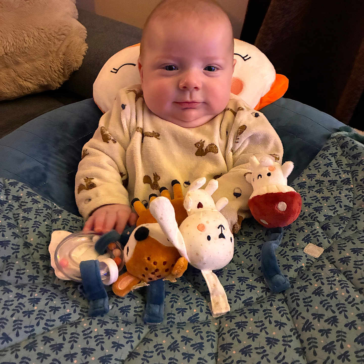 Lysio participe au concours pour gagner de l'argent avec cette photo : baby, blanket, child, clothing, comfort, cozy, cute, face, happy, head_support, indoors, infant, patterned_blanket, person, pillow, plush_toy, sitting, smile, soft_toy, stuffed_animal