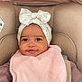 baby, infant, smiling, face, headband, pink_bib, car_seat, child, cute, happy, clothing, portrait, close_up, indoor, young_child, baby_accessory, comfort, seat_belt, soft_texture, adorable