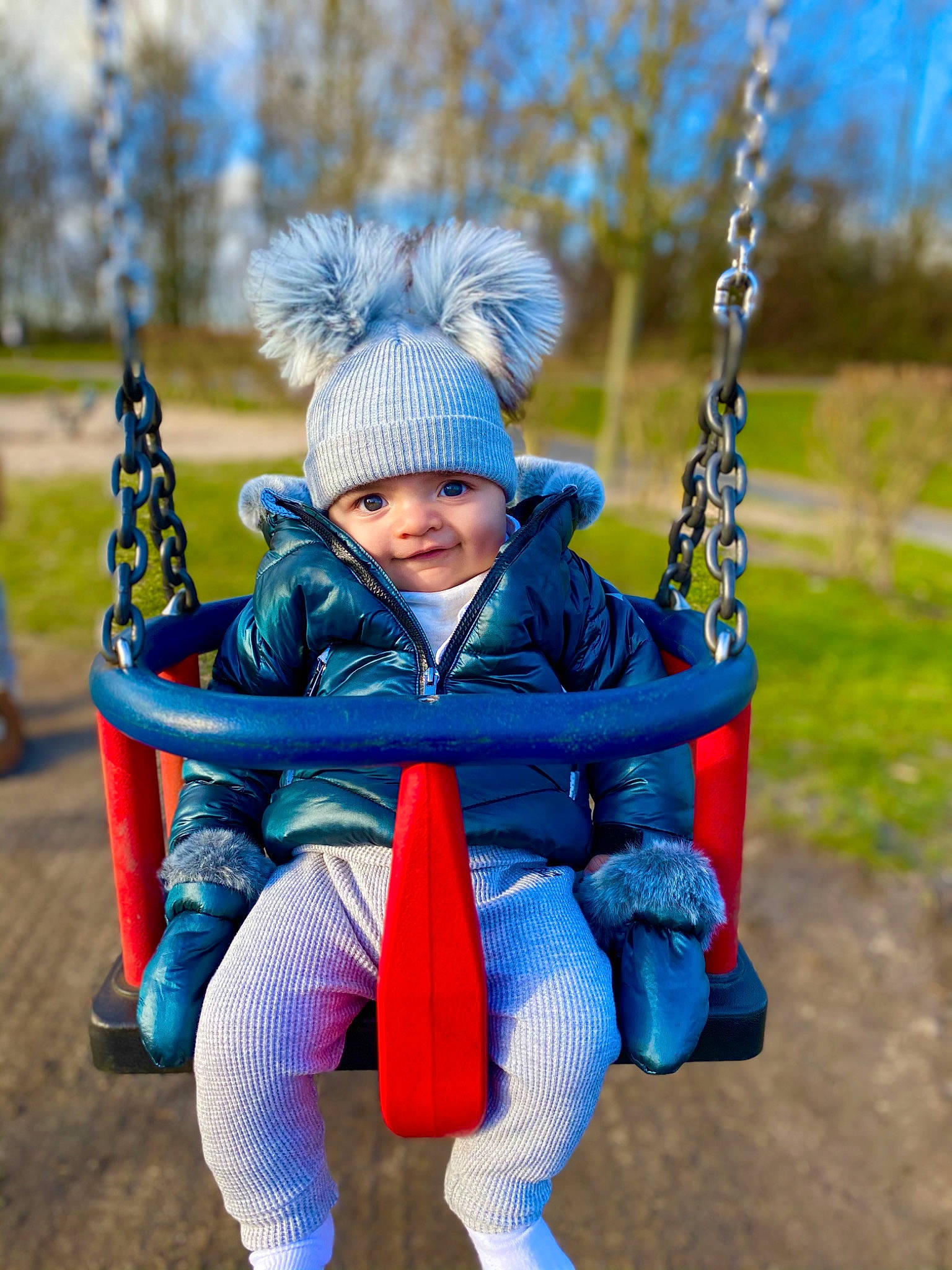 Bo is registered to the contest to win money with this photo: baby, baby_toddler_clothing, child, electric_blue, eye, fun, grass, happy, headwear, jacket, leaf, leisure, people, people_in_nature, person, plant, playground, recreation, swing, toddler
