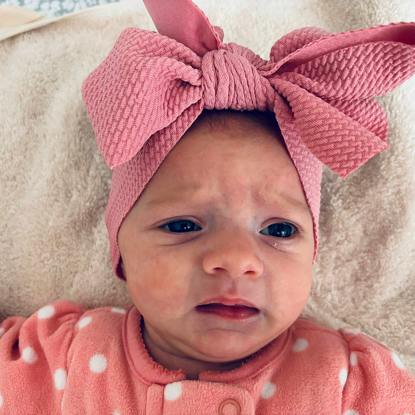 Phoebe is registered to the contest to win money with this photo: baby, bonnet, cap, clothing, crying, face, frown, happy, hat, head, hoodie, knitwear, newborn, person, photography, portrait, sad, scarf, smile, towel