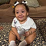 baby, blanket, bottle, bracelet, child, couch, curly_hair, cute, floral_pattern, hair_bows, happy, indoor, infant, milk, person, pillow, sitting, smiling, socks, white_shirt