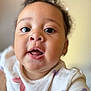 Zoe is registered to the contest to win money with this photo: baby, child, closeup, colorful_pattern, curly_hair, cute, expression, eyes, face, happy, indoors, innocent, natural_light, open_mouth, person, portrait, skin, small_hands, white_shirt, young_child