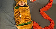 Sitara joined the competition — help win amazing prizes! baby, bear, blanket, child, clothing, costume, cozy, cute, fabric, grey_background, headwear, indoor, lying_down, orange_scarf, peaceful, portrait, resting, sleeping, soft_texture, toddler