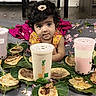 toddler, child, bubble_tea, drink, leaf, flatbread, indoor, floor, curly_hair, hairclip, pink, yellow, food, snack, expression, large_eyes, person, cute, laying, playful