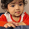 Sitara joined the competition — help win amazing prizes! toddler, child, portrait, face, curly_hair, indoor, clothing, red_shirt, blanket, hands, expression, cute, young, person, skin, eyes, hair, baby, resting, cozy