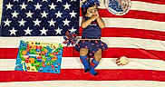 Sitara is registered to the contest to win money with this photo: american_flag, blanket, blue_socks, candle, celebration, child, colorful, cute, dress, festive, headband, holiday, indoor, map, patriotic, pinwheel, smiling, stars, stripes, toddler