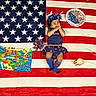 Sitara is registered to the contest to win money with this photo: toddler, child, american_flag, blanket, map, pinwheel, candle, patriotic, blue_socks, dress, headband, celebration, holiday, stars, stripes, indoor, colorful, smiling, cute, festive